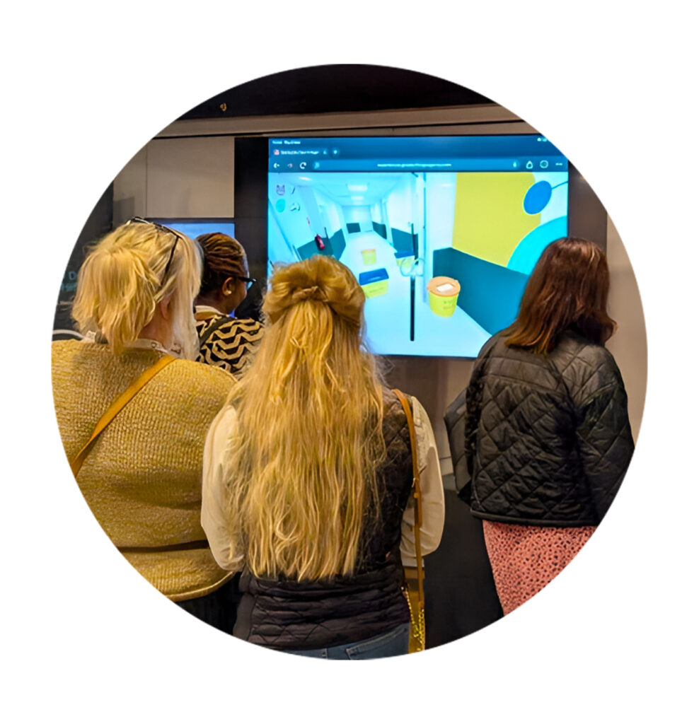 Excited visitors to an exhibition stand look on as one of them plays a game created by us on a big screen. 